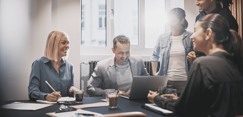 Diverse businesspeople laughing during an office meeting together