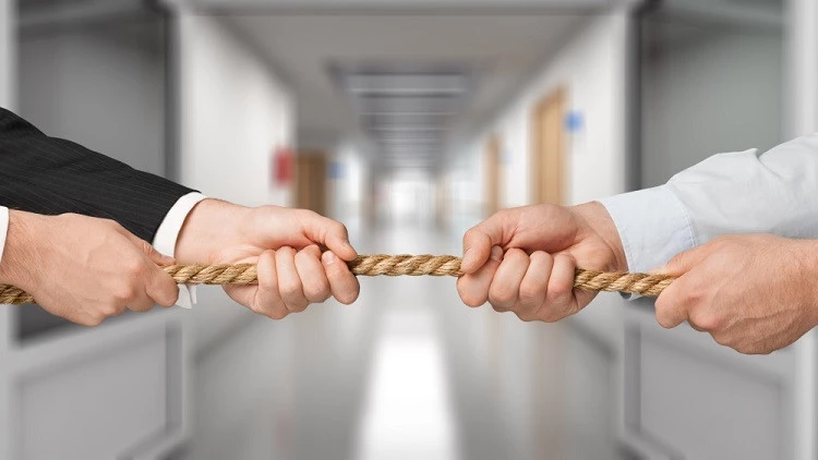 a rope being pulled by two people on opposite ends in suits reflecting resistance to transformation